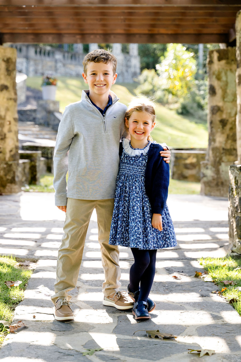 A brother and sister under a stone pergola