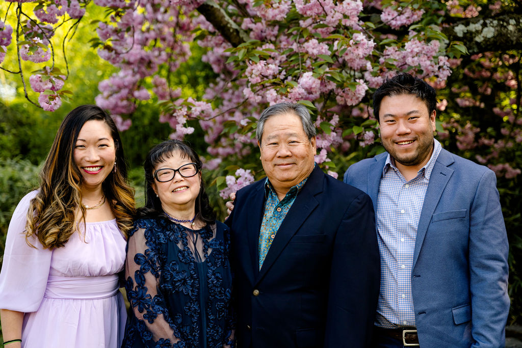 A dressed-up extended family under blossoming trees