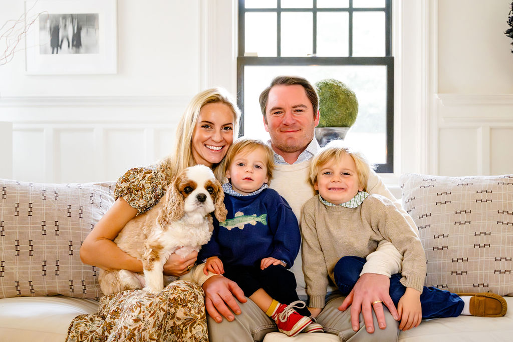 A family and their spaniel on a sofa at home