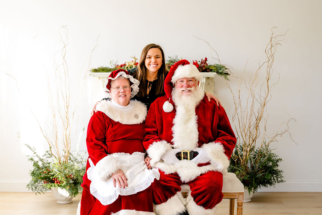 A family posing with Santa and Mrs. Claus at a holiday mini session