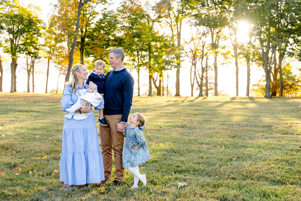 A family standing in a sunlit field at golden hour