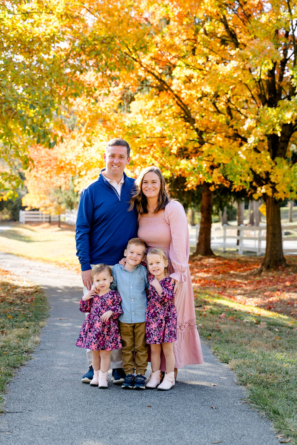 A family under bright yellow fall trees