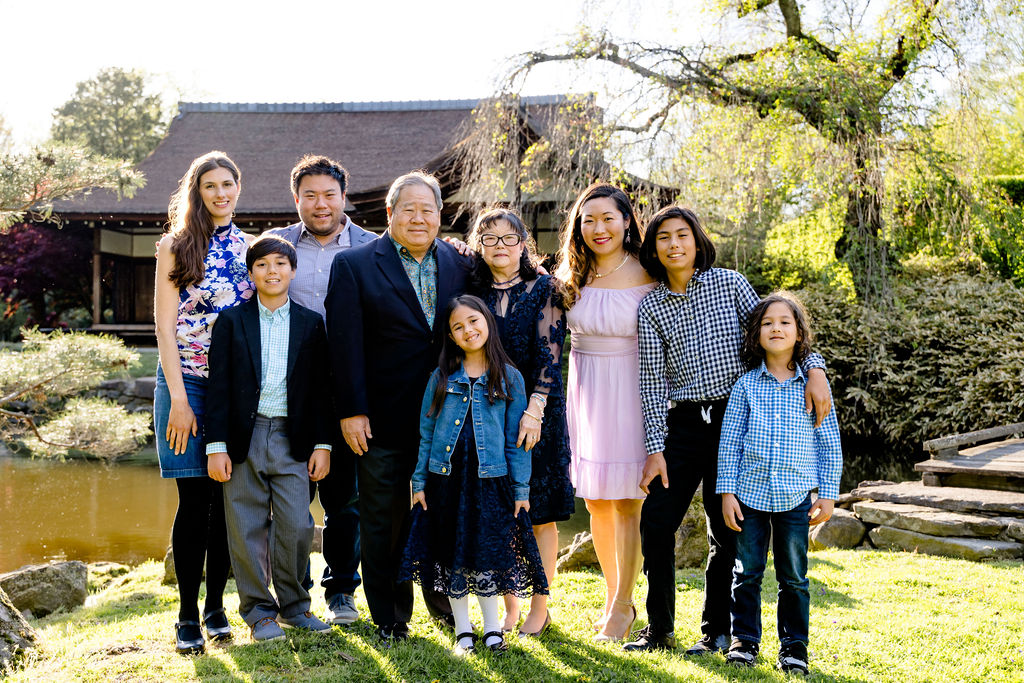 A large dressed-up family gathered in a Japanese garden
