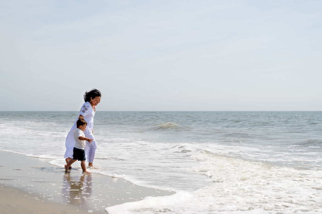 Stand-in for the About hero: a parent and child playing in the waves