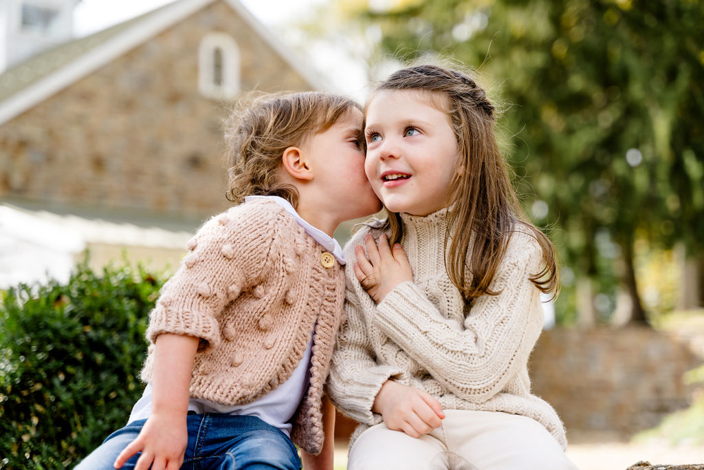 Two sisters sharing a kiss on the cheek